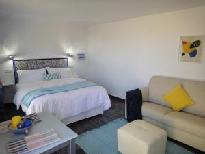 1 dormitorio con 1 cama y 1 sofá en Casa Oasis, en Álora