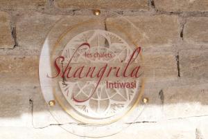 een bord aan de zijkant van een stenen muur bij Chalets Shangrila in Saint-Michel-de-Chaillol