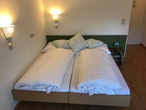 ein Bett mit zwei Kissen auf einem Zimmer in der Unterkunft Chamanna Bed & Breakfast in Arosa