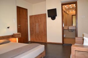 a bedroom with a bed and a bathroom with a tv at Design Hotel Logatero in Sozopol
