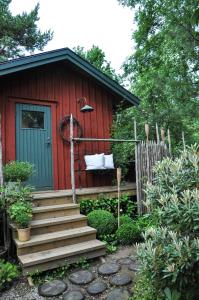 a red cabin with a staircase leading up to it at Håkesgård Bed&Garden in Veddige