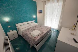 małą sypialnię z łóżkiem i umywalką w obiekcie Residenza Porta Romana w Tropei