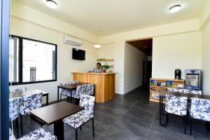 a restaurant with tables and chairs and a person at a counter at Begonia B&B in Taitung City