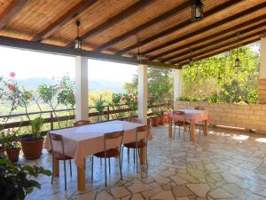 a patio with tables and chairs and a large window at Accommodation Susović in Lastovo