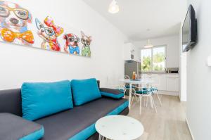 een woonkamer met een blauwe bank en een keuken bij ABC Lapad Apartments in Dubrovnik