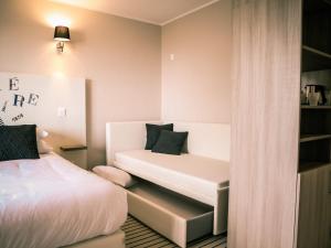 a small room with two beds and a couch at Best Western Plus Antibes Riviera in Antibes