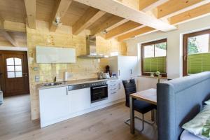 a kitchen with white cabinets and a wooden ceiling at Ferienhaus Albzeit in Albstadt