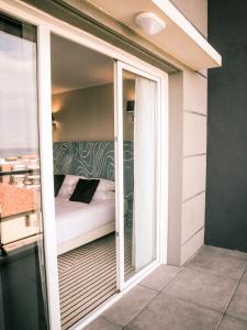 a room with a bed and a sliding glass door at Best Western Plus Antibes Riviera in Antibes