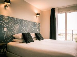 a bedroom with a large bed with a large window at Best Western Plus Antibes Riviera in Antibes
