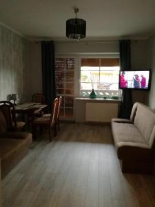 a living room with a couch and a table at Apartament Masajka in Władysławowo