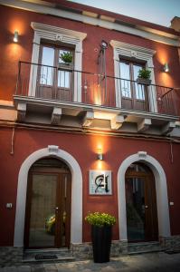 a red building with a balcony on top of it at Alterego B&B in Milazzo