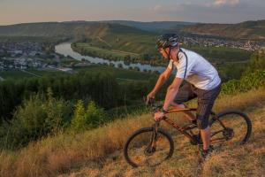 a man riding a bike on a hill at Eurostrand Resort Moseltal in Leiwen