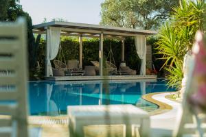 a swimming pool with a gazebo and chairs next to it at Nikoleta Luxury Villa in Limenas