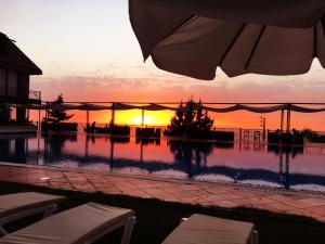 a swimming pool with a sunset in the background at Master's Hotel - Ehden in Ehden