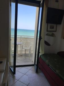 a room with a door open to a balcony with the ocean at Hotel Byron in Milano Marittima