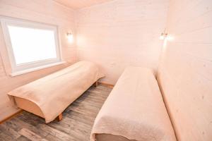 two beds in a small room with a window at Ardonas in Šventoji