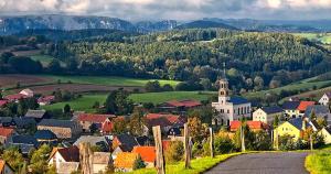 a small town with a church in a valley at Siebers-Ferienwohnung in Saupsdorf