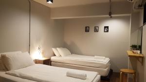 a small room with two beds and a lamp at Non@Chiang Mai in Chiang Mai