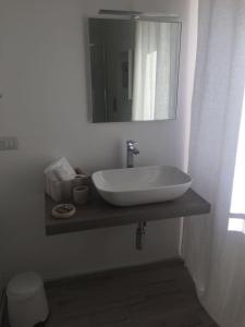 a bathroom with a sink and a mirror on a counter at B&B Piazza Marconi in Manfredonia