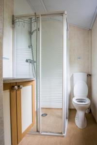 La salle de bains est pourvue de toilettes et d'une douche en verre. dans l'établissement Chalet vakantie Wageningen, à Wageningue