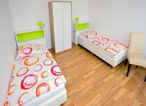 two beds in a room with a table and a chair at Appartements Katharina in Bremerhaven