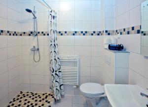 a bathroom with a shower and a toilet and a sink at Appartements Katharina in Bremerhaven +21 photos