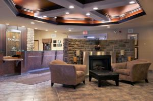 a living room filled with furniture and a fire place at Ramada by Wyndham Drumheller Hotel & Suites in Drumheller