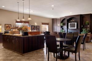 a kitchen with a dining room table and chairs at Ramada by Wyndham Drumheller Hotel & Suites in Drumheller