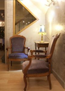 a couple of chairs and a table with a lamp at Les Tilleuls in Saint-Cirgues-de-Jordanne