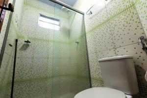 a bathroom with a toilet and a glass shower at Hostel Rua Direita Pirenópolis in Pirenópolis