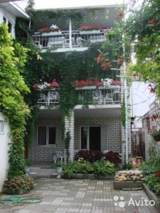 ゲレンジークにあるGuest House on Priboynaya 6の花と植物のあるバルコニー付きの建物