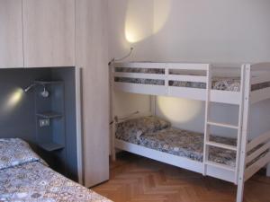 ミラノにあるAppartamento Pasteurの二段ベッド2組とランプが備わる客室です。