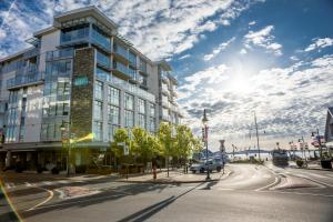 a tall building on a city street with a car at The Sidney Pier Hotel & Spa in Sidney