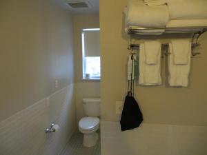 a bathroom with a toilet and a window and towels at The EO Inn - Downtown Orlando in Orlando