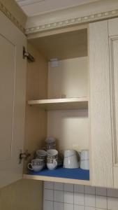 une armoire avec un ensemble de bols et de plaques dans l'établissement Laura's Home, à Durrës