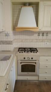 - une cuisine blanche avec cuisinière et évier dans l'établissement Laura's Home, à Durrës