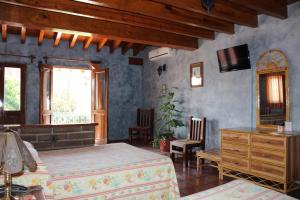 a bedroom with a bed and a dresser and chairs at Hotel La Plaza de Tequisquiapan in Tequisquiapan