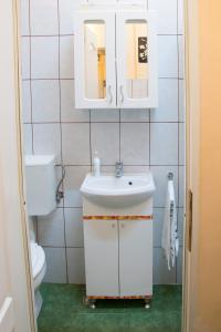 Baño blanco con lavabo y aseo en Garsoniera Alegna, en Sibiu