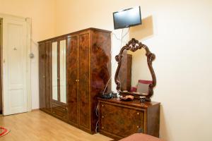 a wooden dresser with a mirror on top of it at Garsoniera Alegna in Sibiu