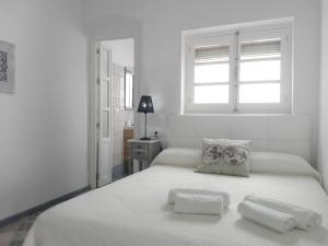 タリファにあるAve María 10の白いベッドルーム(ベッド1台、タオル2枚付)