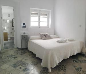 タリファにあるAve María 10の白いベッドルーム(ベッド1台、窓付)