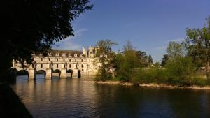 un grande edificio con un ponte sul fiume di La Lézardière a Épeigné-les-Bois
