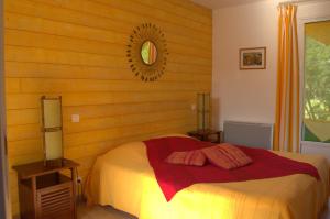 une chambre avec un lit et un miroir au mur dans l'établissement Le Tertre Gatinais, à Saint-Briac-sur-Mer