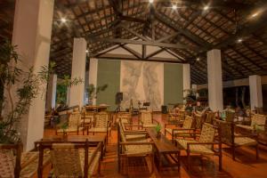 a room with chairs and tables and a large screen at Sigiriya Village in Sigiriya