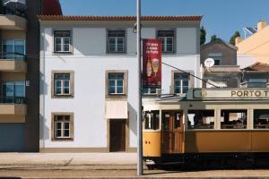 a trolley car parked in front of a building at Duas Portas Townhouse in Porto