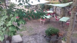 un jardin avec une table et des chaises sous un arbre dans l'établissement Chambres d'hôtes du Rebemol, à Le Monastier sur Gazeille