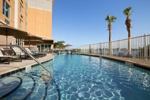 a swimming pool at a hotel with palm trees at Cambria Hotel Miami Airport - Blue Lagoon in Miami