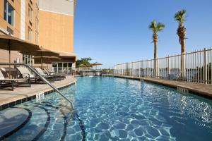 una piscina en un hotel con palmeras en Cambria Hotel Miami Airport - Blue Lagoon, en Miami