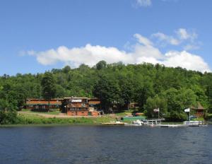 a large house on the shore of a lake at AJ's Lodge and Oven in Bergland
