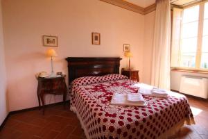 ein Schlafzimmer mit einem Bett mit einer rot-weißen Tagesdecke in der Unterkunft App.to Le antiche Poste in Piegaro